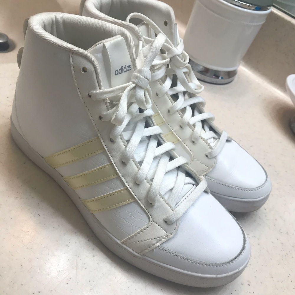 Woman’s white Adidas high tops
